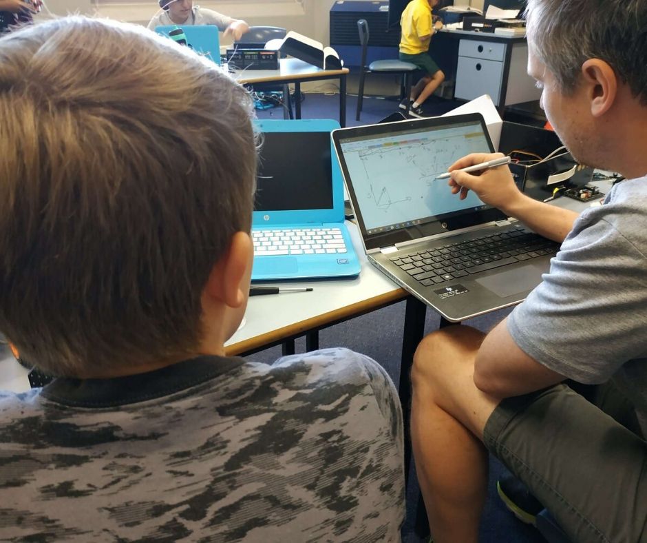 School student works with a teacher on a science project without using AI