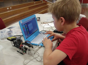 A boy is using robotics kit to build and code a robot to learn robotics and STEM