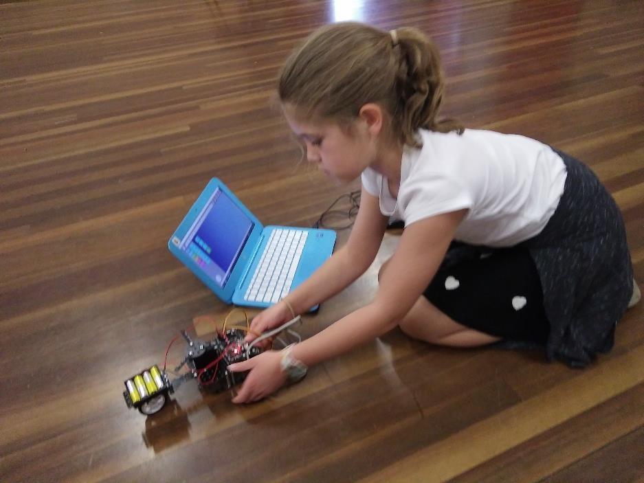 A girl is testing a robot she has build using Makers Step 1 robotics kit