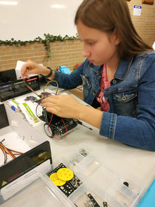 Girl is building a robot at online robotics class for kids